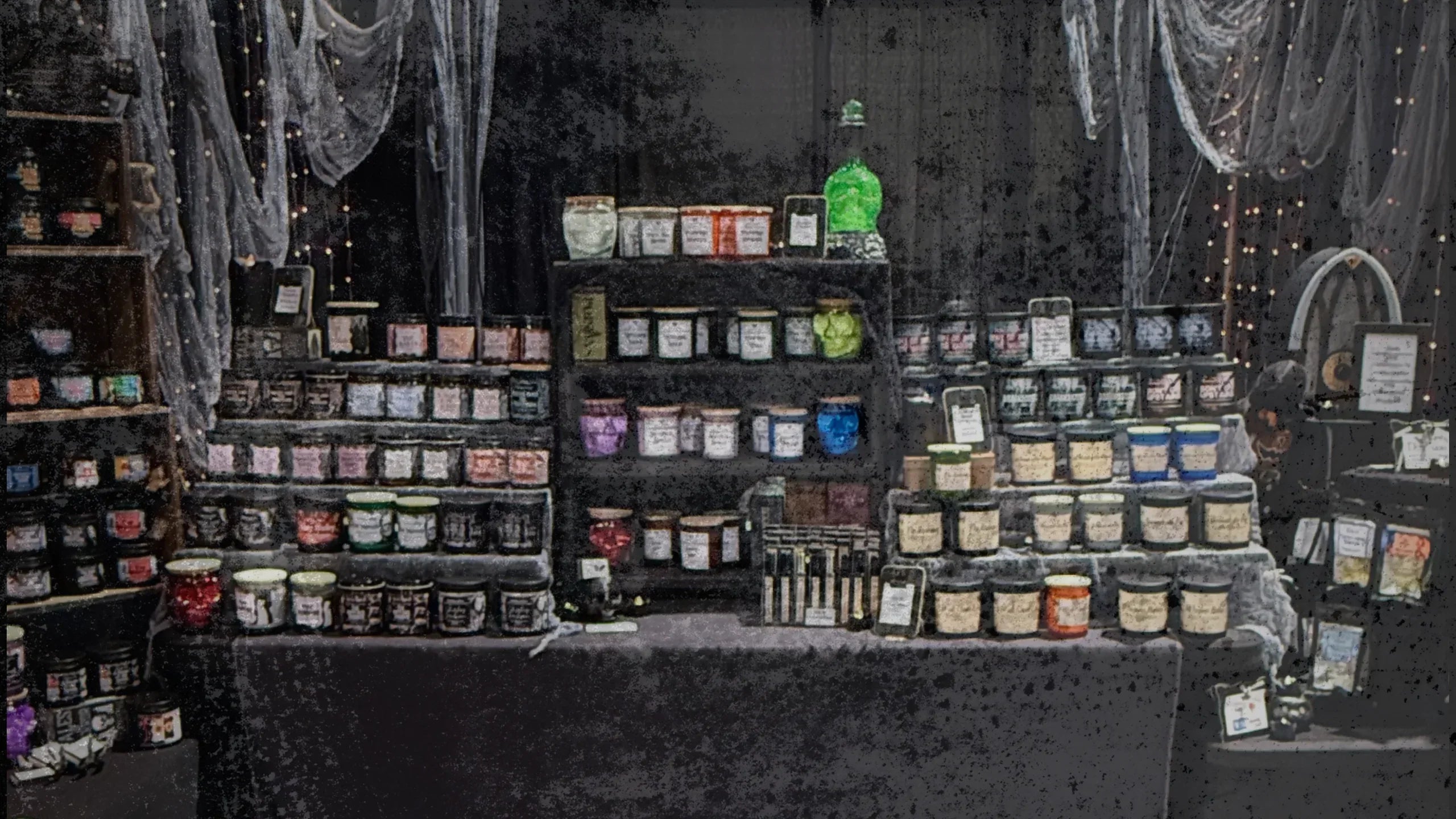 Display of horror-themed candles in jars, gothic decor, eerie lighting, spooky table setup